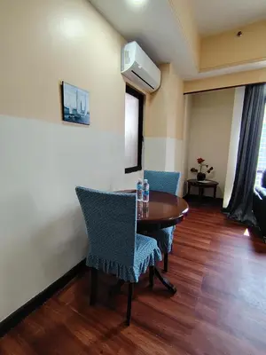 a room with a table and chairs and a television at Grand Lumia Suite At Times Square KL in Kuala Lumpur