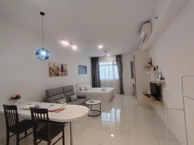 a white living room with a table and a couch at SUITES At CHAMBERS KLCC KUALALAMPUR in Kuala Lumpur