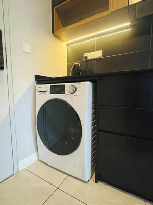 a white washing machine sitting in a kitchen at Axon Purple Suite Kuala Lampur in Kuala Lumpur