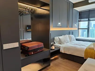 a bedroom with a bed and a suitcase at Ceylonz Suites, Bukit Bintang, Kuala Lumpur in Kuala Lumpur