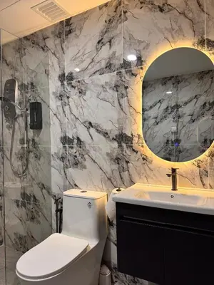 a bathroom with a toilet and a sink and a mirror at Luxury Sky Homes with KLCC VIEW in Kuala Lumpur