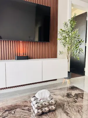 a living room with a white dresser with a tv on a wall at Luxury Sky Homes with KLCC VIEW in Kuala Lumpur