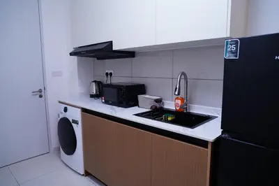 a kitchen with a sink and a black refrigerator at Luxury Suites Majestic Residences at Heart of KLCC in Kuala Lumpur