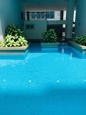 a large blue swimming pool in a building at Sweet cozy house by seri bukit Ceylon in Kuala Lumpur