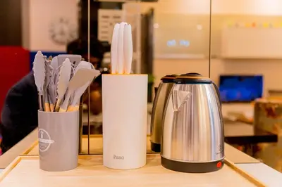 two containers with utensils and a kettle on a counter at KidsCastle Dorsett Pavillion in Kuala Lumpur