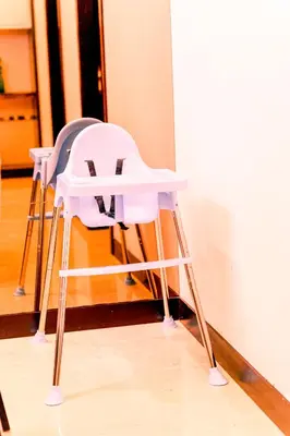 two white high chairs sitting next to a wall at KidsCastle Dorsett Pavillion in Kuala Lumpur