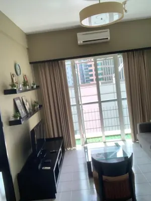 a living room with a table and a large window at seri bukit ceylon by sweet cozy house in Kuala Lumpur