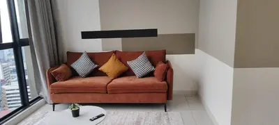 a living room with a brown couch with pillows at Majestic Infinity Pool by KLCC in Kuala Lumpur