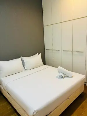a white bed with a towel on top of it at Majestic Infinity Pool by KLCC in Kuala Lumpur