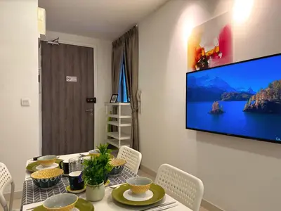 a dining room with a table and a television on a wall at 4BR KLCC View MRT 2min Free Parking Big Unit in Kuala Lumpur