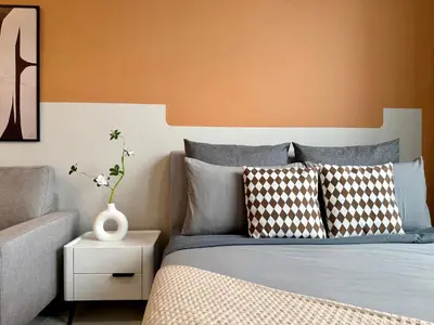 a bedroom with a bed with an orange wall at The Majestic Residence Suites By Casabellestay in Kuala Lumpur