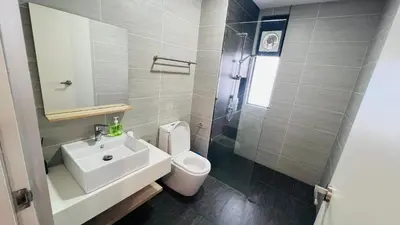 a bathroom with a sink and a toilet and a mirror at TRION KL Premier Residence in Kuala Lumpur