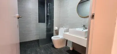 a bathroom with a toilet and a sink and a mirror at TRION KL Premier Residence in Kuala Lumpur