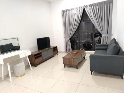 a living room with a tv and a couch and a table at TRION KL Premier Residence in Kuala Lumpur