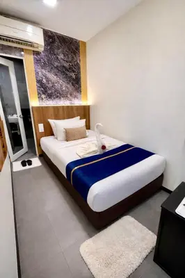 a bedroom with a large bed with a window at Swiss Hotel at City Centre in Kuala Lumpur