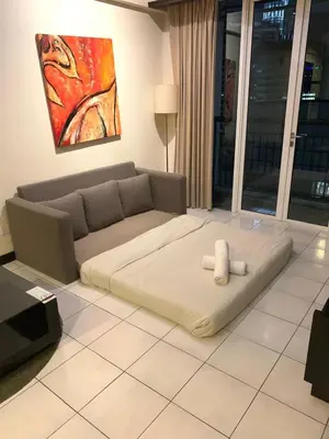 a living room with a couch and a white bed at Seri bukit Ceylon by anhome changkat in Kuala Lumpur