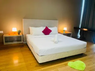 a bedroom with a large white bed with red pillows at The Platinum Suite KL in Kuala Lumpur
