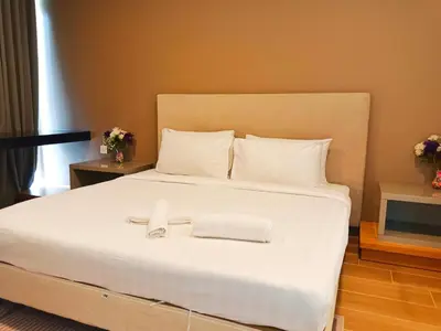a bedroom with a large white bed with towels on it at The Platinum Suite KL in Kuala Lumpur