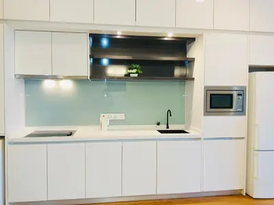 a white kitchen with a sink and a microwave at The Platinum Suite KL in Kuala Lumpur