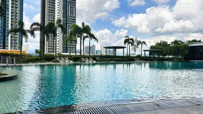 a large swimming pool with palm trees and buildings at Couple nest A37 10St Trion KL in Kuala Lumpur