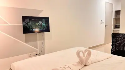 a room with a bed with a tv on a wall at Couple Private studio B22 11 Trion KL in Kuala Lumpur