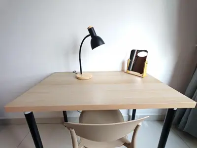 a wooden desk with a lamp and a chair at O 3 Room 200mbps wifi near Mrt Lrt HKL PWTC KLCC in Kuala Lumpur