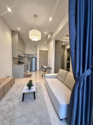 a living room with a couch and a blue curtain at Lucentia Residences By CasaLuxe in Kuala Lumpur