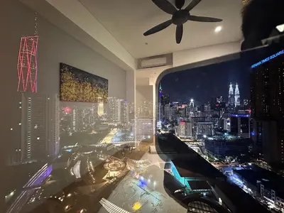 a room with a view of a city at night at Lucentia Residences By CasaLuxe in Kuala Lumpur