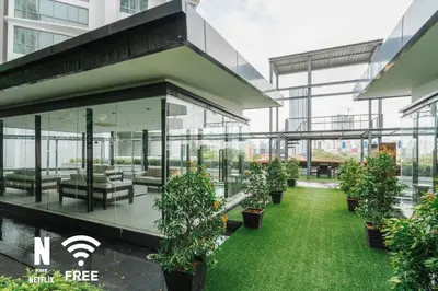 an office building with a green lawn and plants at Gleneagles Hospital - 3BR with Pool & Near KLCC in Kuala Lumpur
