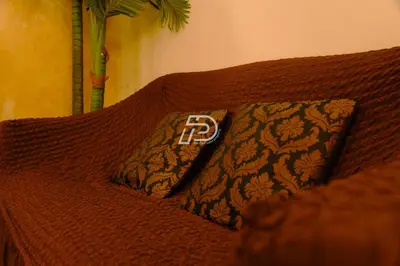a brown couch with a pillow with the letter r on it at KL Hartamas 1BR, Mall Link, Wifi Smart TV in Kuala Lumpur
