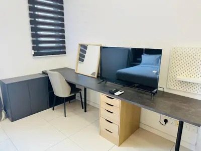 a desk with a tv and a bed in a room at Chamber Haven KL in Kuala Lumpur