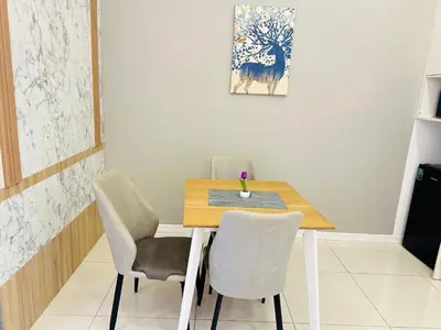 a dining room with a wooden table and chairs at Chamber Haven KL in Kuala Lumpur
