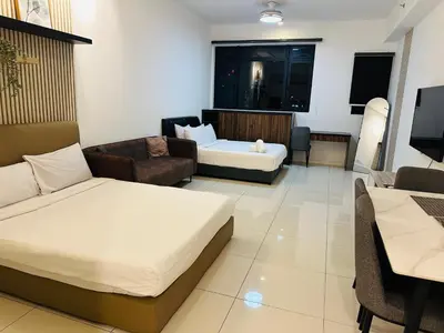 a hotel room with two beds and a living room at Chamber Haven KL in Kuala Lumpur
