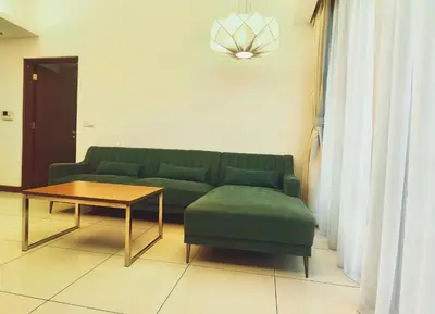 a living room with a green couch and a table at Suasana Suites by Lisa in Kuala Lumpur