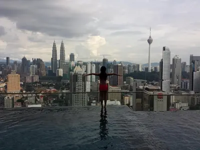 a woman standing on the edge of a city skyline at Amazing KLCC View @ Regalia Residence in Kuala Lumpur