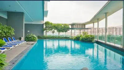 a large swimming pool in a building with blue chairs at 0710 Sweet Home-Casa Residency 2R 2B in Kuala Lumpur