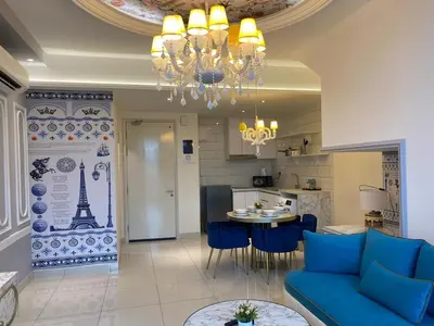 a living room with a blue couch and a kitchen at Stylish 2 bedroom duplex bedroom city center in Kuala Lumpur