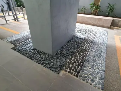 a column in a building with rocks on the sidewalk at Compact Studio Near Gleneagles KLCC in Kuala Lumpur