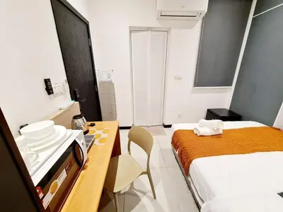 a small room with a bed and a table with plates on it at Neu Suites Tiny Queen Bed Studio 10 mins to KLCC in Kuala Lumpur