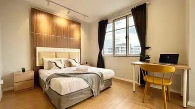 a bedroom with a bed and a desk with a laptop at Holiday Place Residence Kuala Lumpur in Kuala Lumpur
