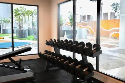 a gym with a row of dumbbells in a gym at Near in Kuala Lumpur