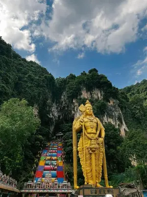 a large golden statue in front of a mountain at Near in Kuala Lumpur