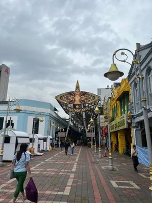 a woman walking down a street with a star sculpture at Near in Kuala Lumpur