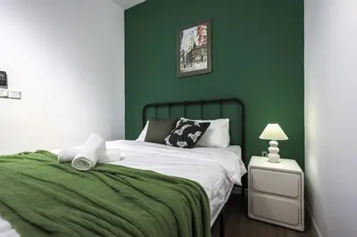a green bedroom with a bed and a green wall at M Vertica Home Plus in Kuala Lumpur