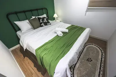 a bedroom with a large bed with a green headboard at M Vertica Home Plus in Kuala Lumpur