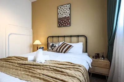 a bedroom with a large bed with white sheets at M Vertica Home Plus in Kuala Lumpur