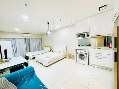 a living room with a couch and a kitchen at Luxury Mercu Summer Suites KLCC By Majestic in Kuala Lumpur