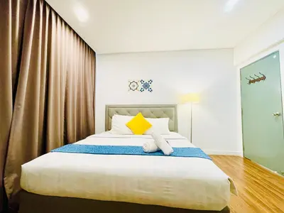 a bedroom with a large bed with a yellow pillow at Luxury Mercu Summer Suites KLCC By Majestic in Kuala Lumpur