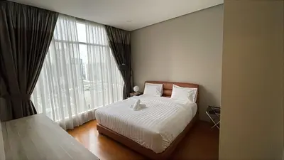 a bedroom with a bed and a large window at Soho Suites KLCC by City Keys in Kuala Lumpur