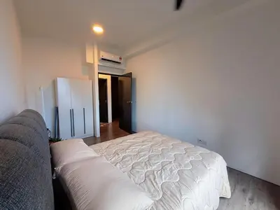 a bedroom with a white bed and a couch at 2BR with Balcony High Floor, Henna Residence Near LRT Sri Rampai & Wangsa Walk Mall in Kuala Lumpur